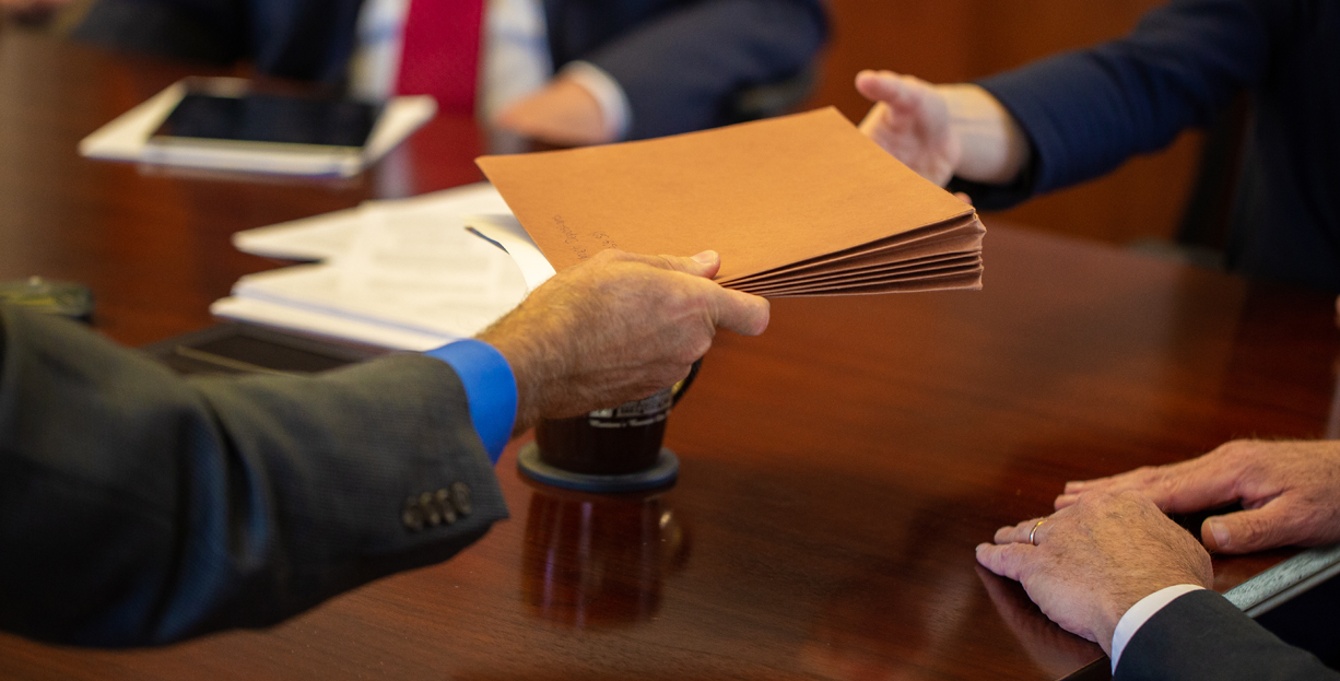 Handing folder across table